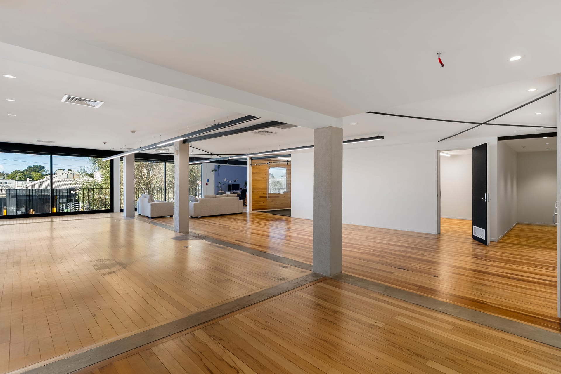 Light-filled private team space with timber floor and leafy outlook at Thinkspace Morningside
