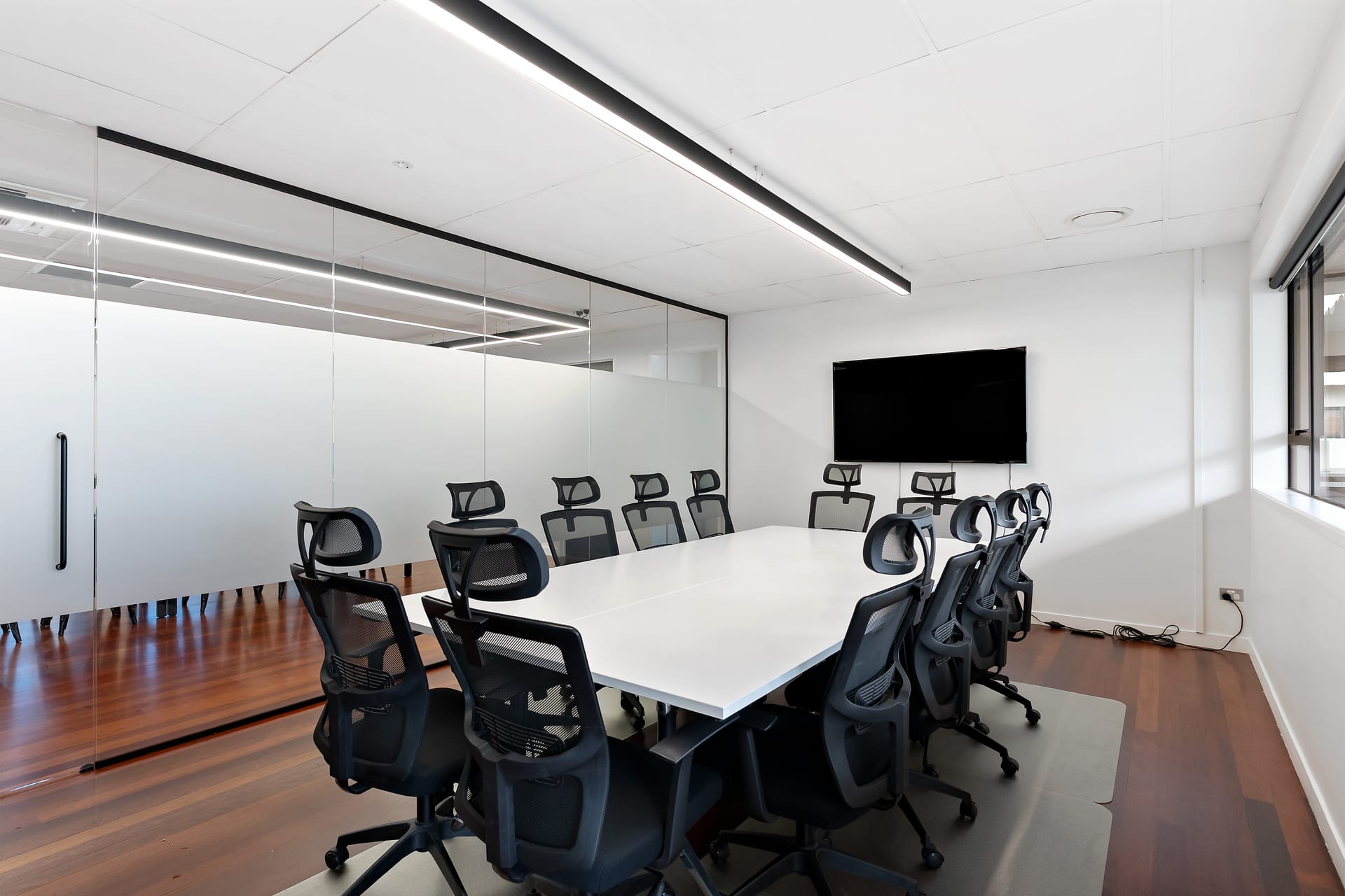 Boardroom filled with natural light beside heritage windows at Thinkspace Parnell