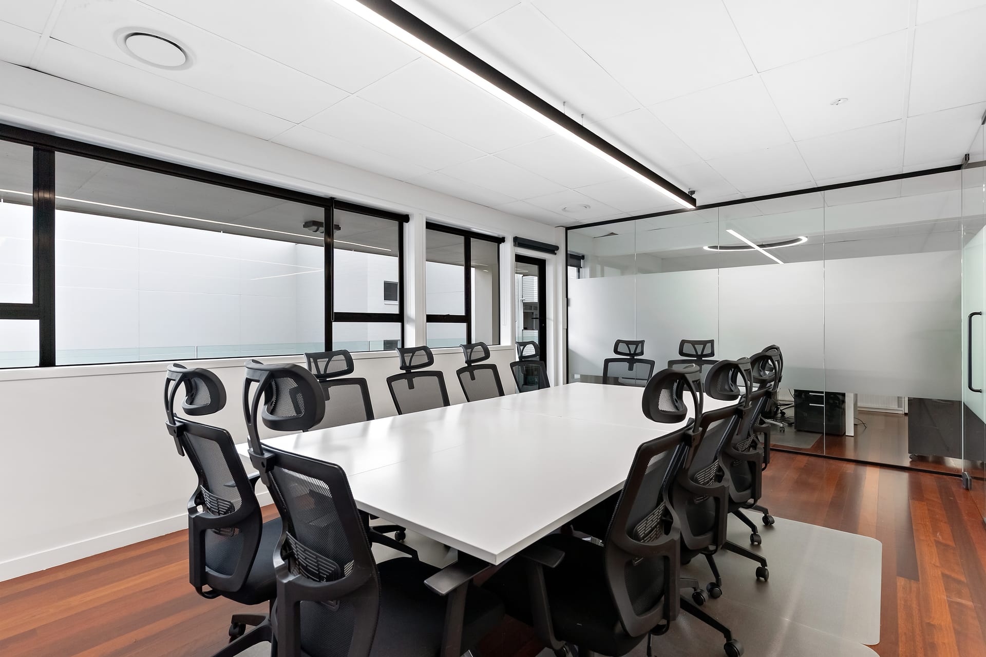 Executive boardroom with long table and glass partition at Thinkspace Parnell