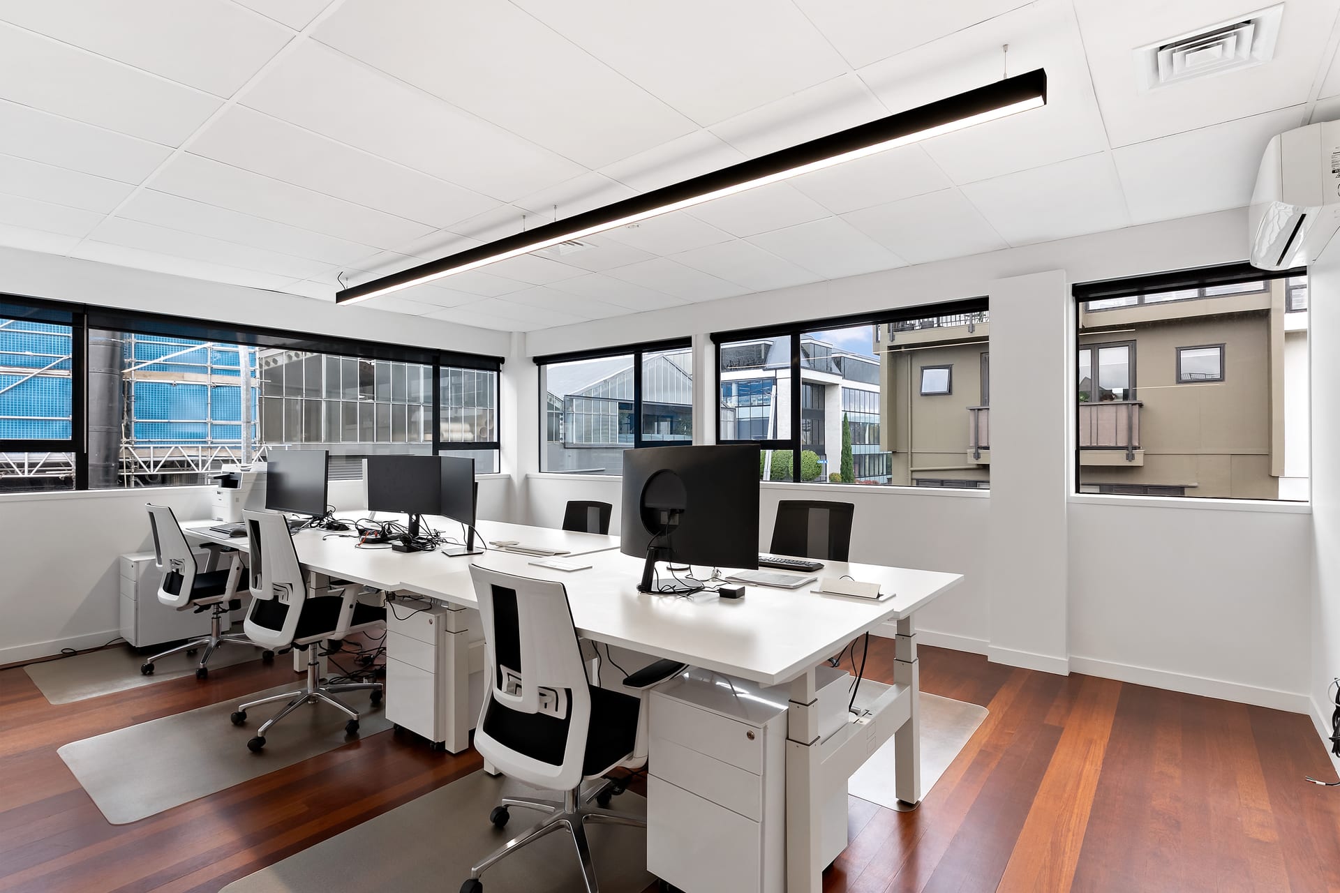Open-plan coworking floor with corner windows and city outlook at Thinkspace Parnell
